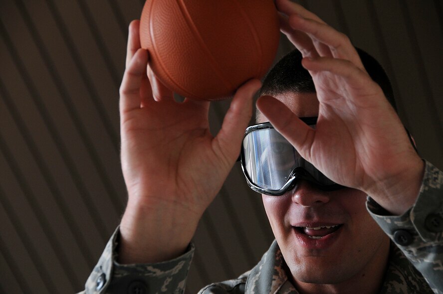 Airman 1st Class Ivan Lich, 18th Medical Group dental lab technician, tries to shoot a basketball into a hoop while wearing drunk goggles reflecting a blood alcohol content level of .25 during an outreach event for the National Drunk and Drugged Driving Prevention Month at Kadena Air Base, Dec. 15. Members of the 18th Wing participated in different activities that demonstrated how alcohol affected their ability to perform. (U.S. Air Force photo/Staff Sgt. Darnell T. Cannady)