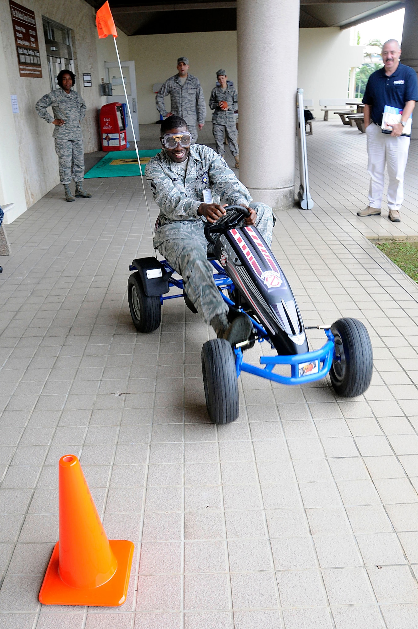 Master Sgt. Tevin Austin, a member of the 18th Medical Group, tries to navigate the “drunk buster” bike around cones while wearing drunk goggles during a National Drunk and Drugged Prevention Month outreach event at Kadena Air Base, Dec. 15. This event demonstrated how navigating a simple course becomes harder while under the influence. (U.S. Air Force photo/Staff Sgt. Darnell T. Cannady)