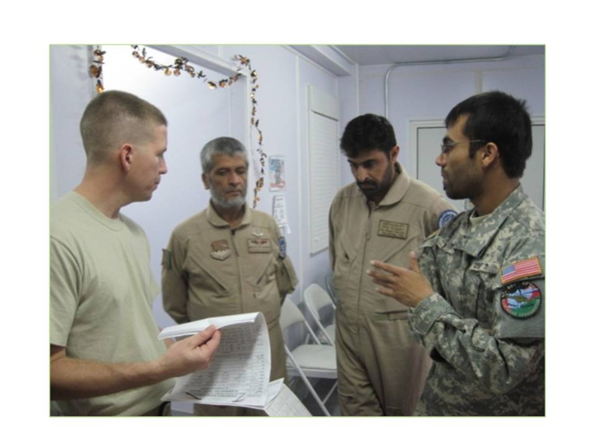 KANDAHAR, Afghanistan - A U.S. Air Force Airman displays a sample medical record to the Kandahar Air Wing Flight Surgeon and Dentist during a visit the two had to the 451st Air Expeditonary Wing Medical Clinic. (Photo courtesy of US Air Force/RELEASED)