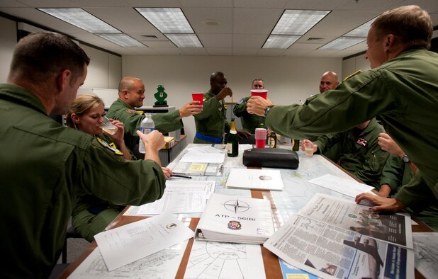 Lt. Col. Brian Hill (center), 96th Air Refueling Squadron commander, toasts to a successfully completed mission Dec. 14 at Joint Base Pearl Harbor-Hickam, Hawaii. During the squadron's first operational mission, a 96th ARS KC-135 Stratotanker joined a KC-135 from the Iowa Air National Guard as part of a two-ship formation to refuel two B-52 Stratofortresses on the way to Guam.(U.S. Air Force photo/Staff Sgt. Nathan Allen)