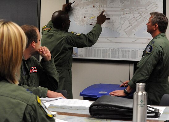 Lt. Col. Brian Hill, 96th Air Refueling Squadron commander and aircraft commander for the squadron's first operational refueling mission, reviews aircraft taxiing routes with members of both the 96th ARS and Iowa Air National Guard Dec. 14 at Joint Base Pearl Harbor-Hickam, Hawaii. During the mission, a 96th ARS KC-135 Stratotanker joined a KC-135 from the Iowa Air Guard as part of a two-ship formation to refuel two B-52 Stratofortresses on the way to Guam. (U.S. Air Force photo/Staff Sgt. Nathan Allen)