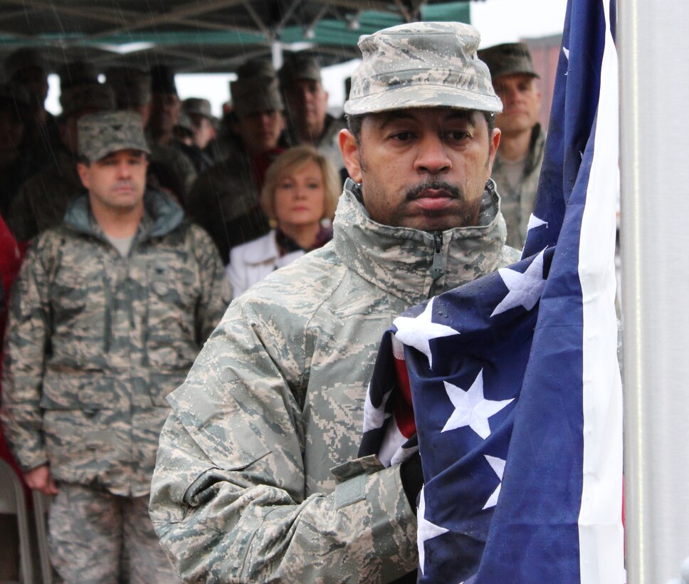 Scott Air Force Base, Ill.--- Master Sgt. Richard Coleman helps raise the U.S. flag during the plaque dedication for Tech. Sgt. Anthony Campbell who was killed in operations while deployed to Afghanistan in December 2009. The engraved plaque is mounted on the flag pole base in front of the 932nd Airlift Wing headquarters building.  Sergeant Campbell was an explosive ordnance disposal specialist assigned to the 932nd Civil Engineer Squadron. Sergeant Campbell's wife and children attended the special dedication.  (U.S. Air Force photo/Tech. Sgt. Gerald Sonnenberg)