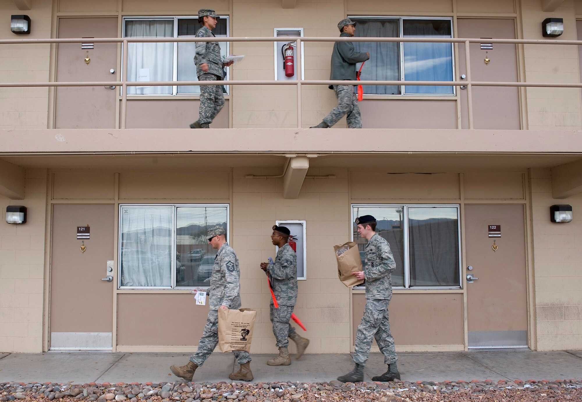 NELLIS AIR FORCE BASE, Nev. -- Volunteers walk through the Nellis dormitories Dec. 14 delivering more than 13,000 cookies for the Annual Cookie Drive. The cookie drive is held during the holidays for single Airmen living in the dorms. (U.S. Air Force photo by Senior Airman Brett Clashman/Released)
