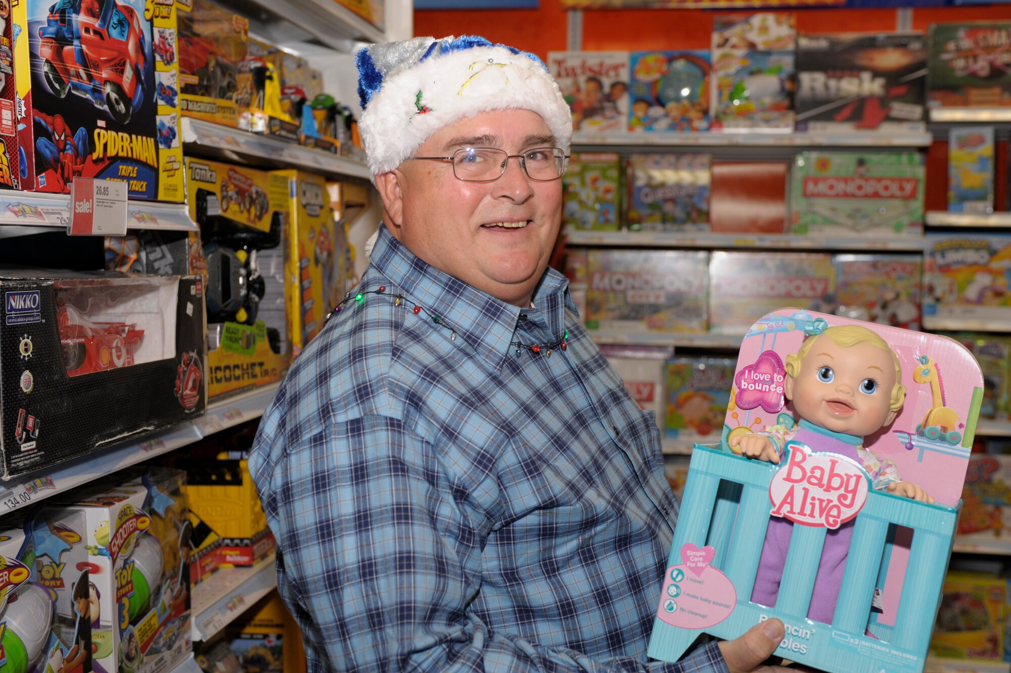 J.R Ivy holds a Baby Alive as he shops for the Christmas Angels at the Base Exchange Dec. 11. The Christmas Angels is a charity program designed to give less fortunate children gifts at Christmas time. (U.S. Air Force photo by Airman Ericka Engblom)