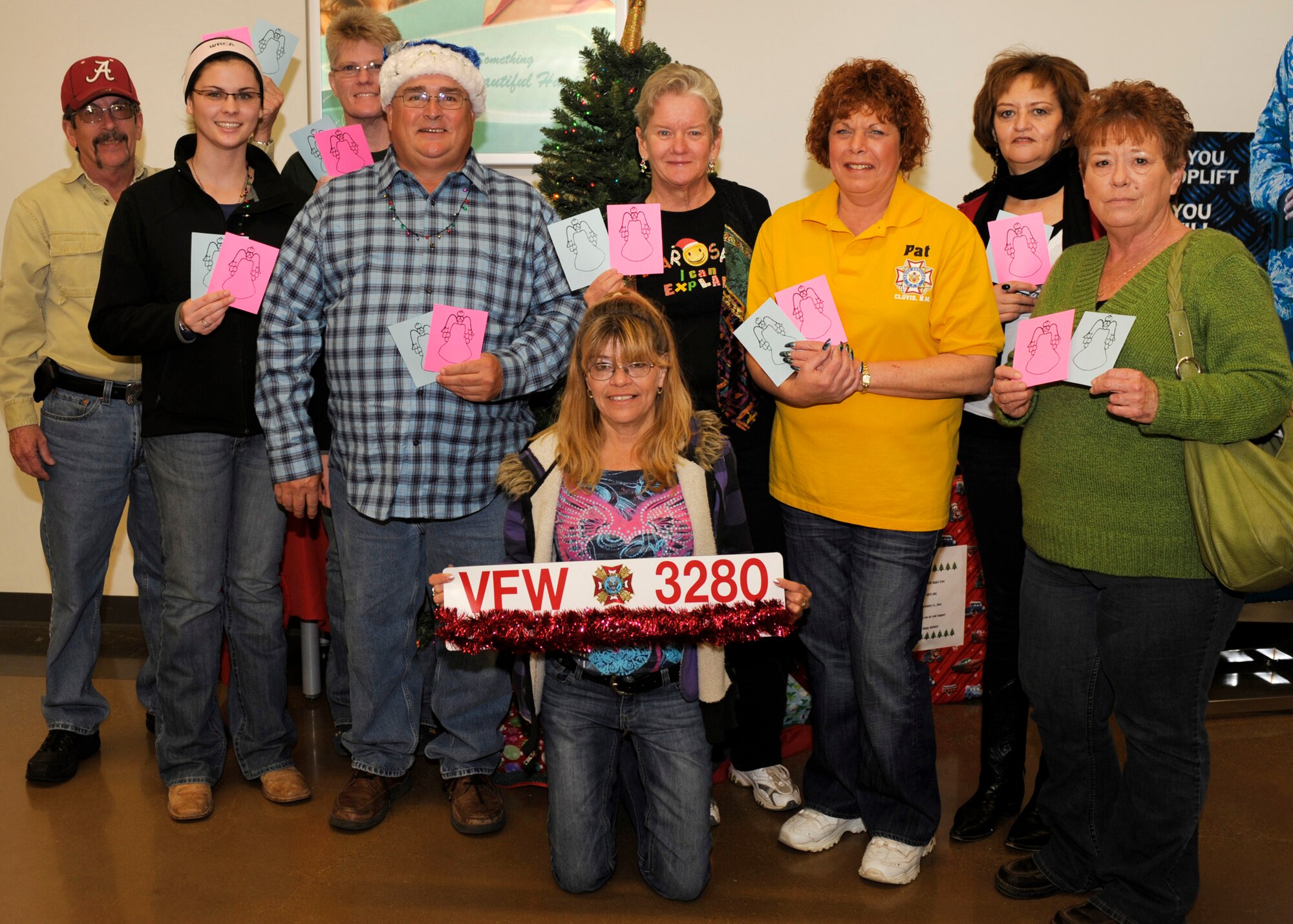 The Christmas Angels (from the left) Dan Ellis, Jessica Ivy, Julie Ivy, J.R. Ivy, Susan Willis,(kneeling,) Charmange Howard, Pat Ellis, Jodi, and Sharon Lynn, gather outside the Base Exchange for a group photo Dec. 11. The Christmas Angels spent the day shopping for less fortunate children's Christmas presents. (U.S. Air Force Photo by Airman Ericka Engblom)


