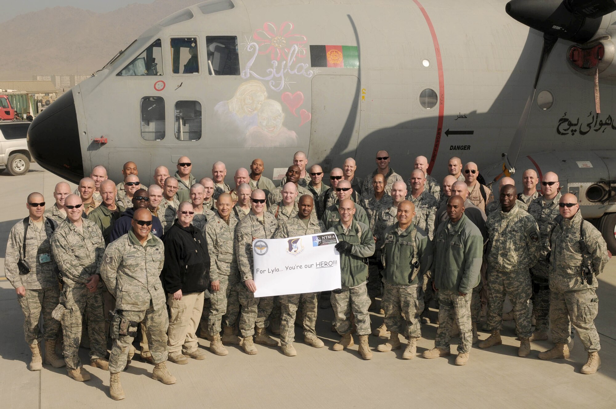 Members of the NATO Air Training Command - Afghanistan participate in a group photo for Lyla, a cancer patient and the St. Jude's Childrens Research Hospital Dec 9, 2010. (U.S. Navy photo/ Petty Officer Jared E. Walker)