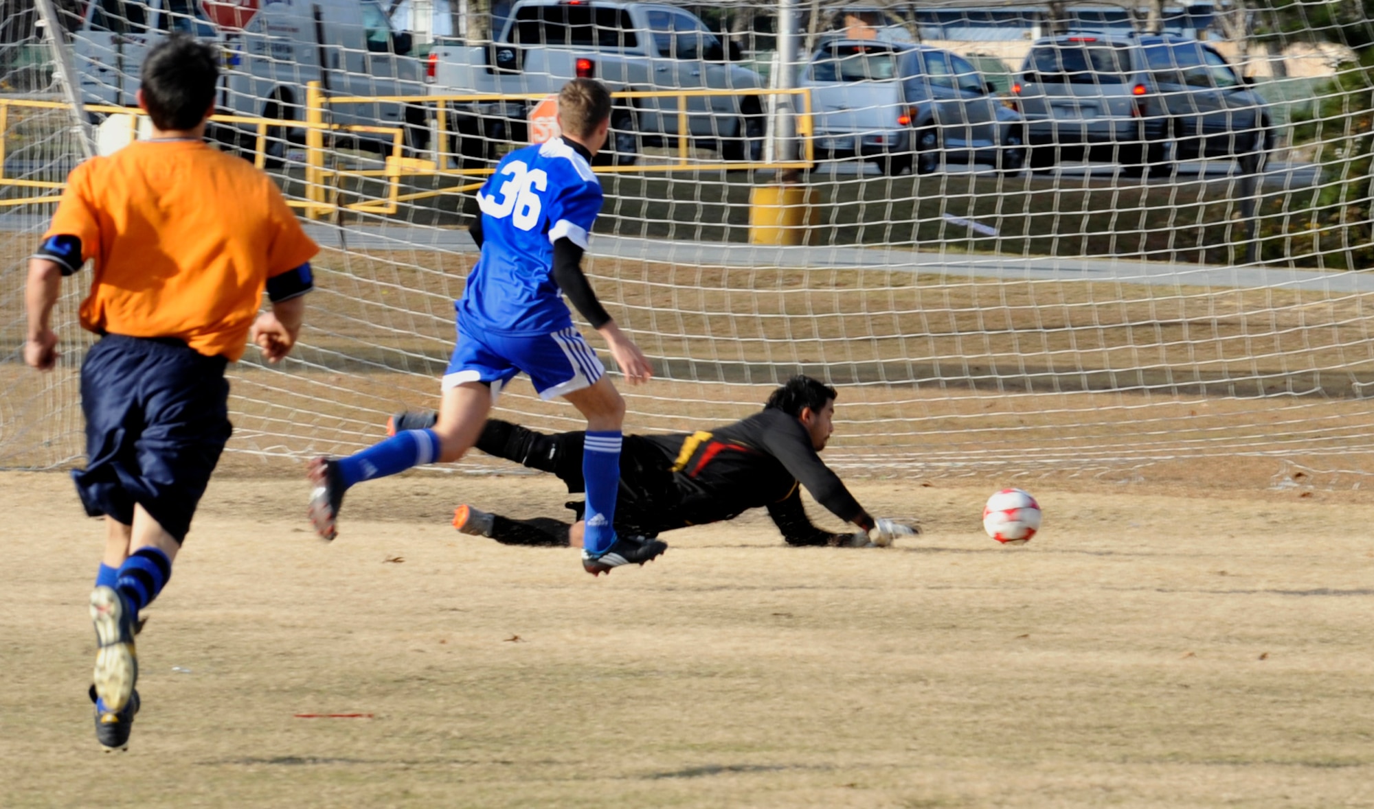 Valdosta, Ga. -- Francisco Ramirez goalie for Quitman, Ga. dives for a ball as Daniel Fischer scores a goal in the beginning of the game Dec. 12. Moody made quick work of Quitman as the final score of the match was 4-1. (U.S. Air Force photo/Airman 1st Class Nicholas Benroth)(RELEASED)
