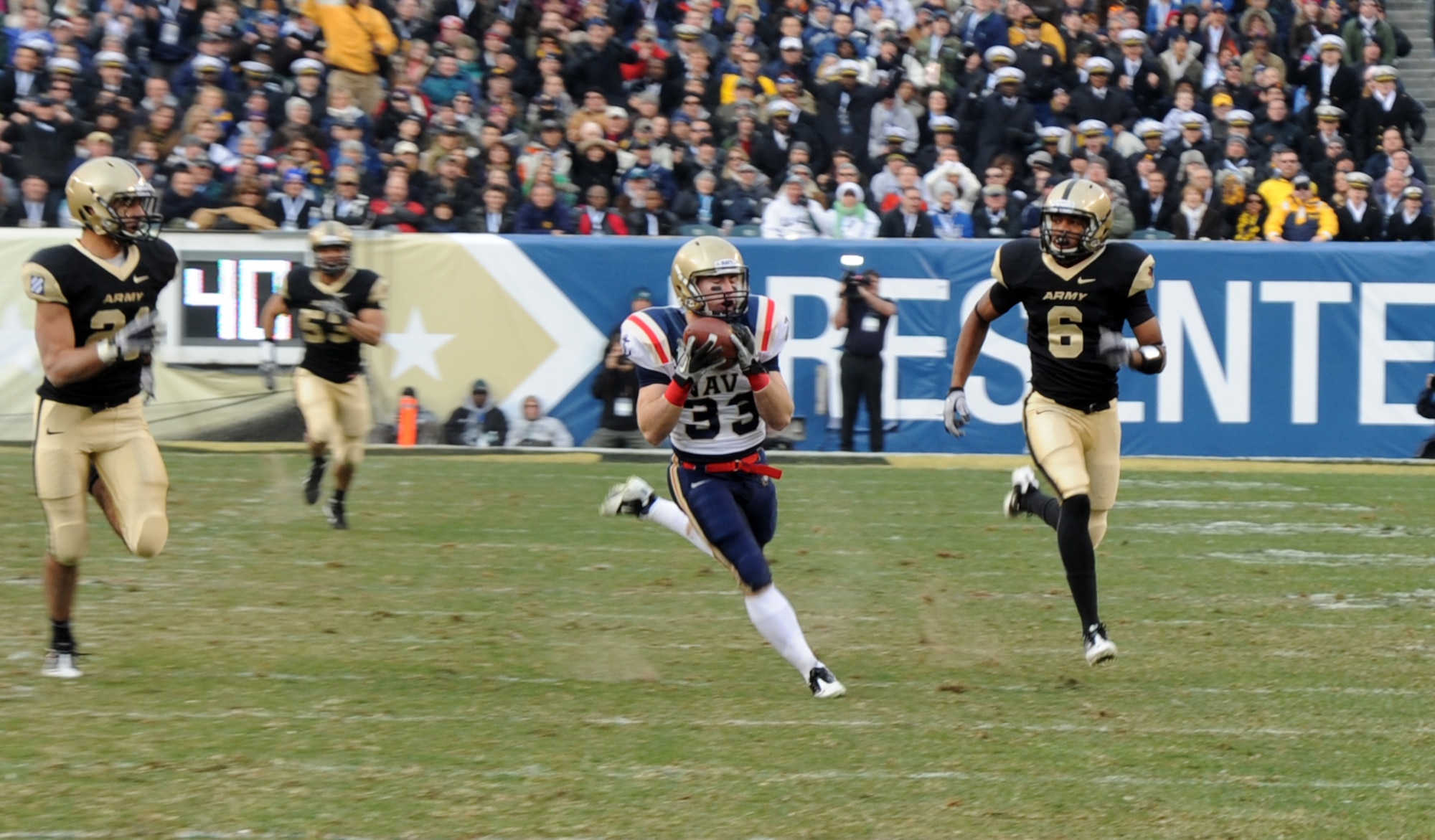 U.S. Naval Academy Slotback John Howell (No. 33) hauls in a long pass and sprints away from Army defenders during the Army vs. Navy game Dec. 11 at Philadelphia’s Lincoln Financial Field. Howell finished the game with one catch for 77 yards and one touchdown. The Navy Midshipmen defeated the Army Black Knights 31-17 in the 111th meeting between the two academies. This was Navy’s ninth consecutive victory over rival Army. (U.S. Air Force photo/Senior Airman David Carbajal)