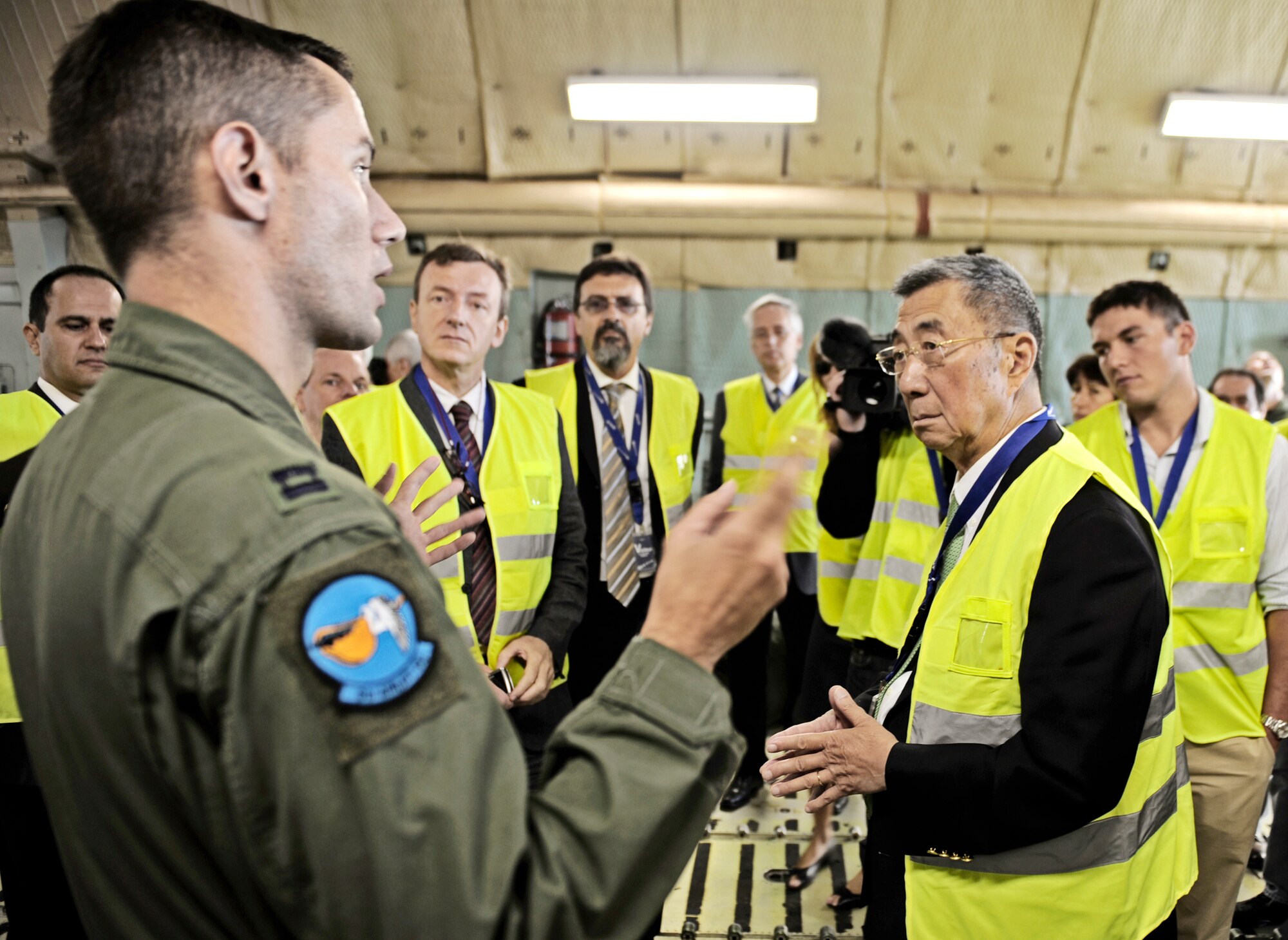 Capt. Cory Damon speaks to Dr. Samuel Ting (right) and other scientists and engineers Aug. 25, 2010, in Geneva, Switzerland, about the C-5M and how it is the perfect choice for transporting the Alpha Magnetic Spectrometer. An Air Mobility Command crew delivered the $2 billion AMS from Geneva, Switzerland to Cape Canaveral, Fla. The AMS is designed to detect particles in outer space and is scheduled to be delivered to the International Space Station by a NASA space shuttle. Captain Damon is a 9th Airlift Squadron C-5M Super Galaxy pilot. (U.S. Air Force Photo/Staff Sgt. Ryan Crane)