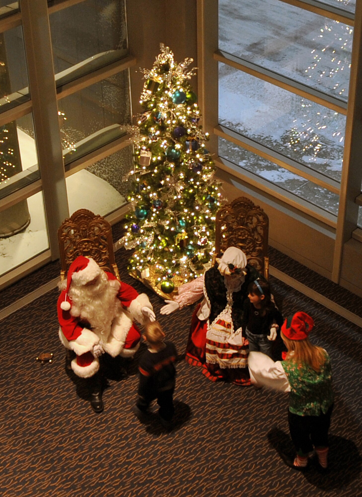 OFFUTT AIR FORCE BASE, Neb. - Children sit on Santa's lap at the Heartland of America Band?s annual holiday concert Dec. 8 at the Holland Performing Arts Center in downtown Omaha. The annual holiday concert is a way Team Offutt works with local businesses like the Omaha World Herald to give back to the community. U.S. Air Force Photo by Jeff W. Gates (Released)