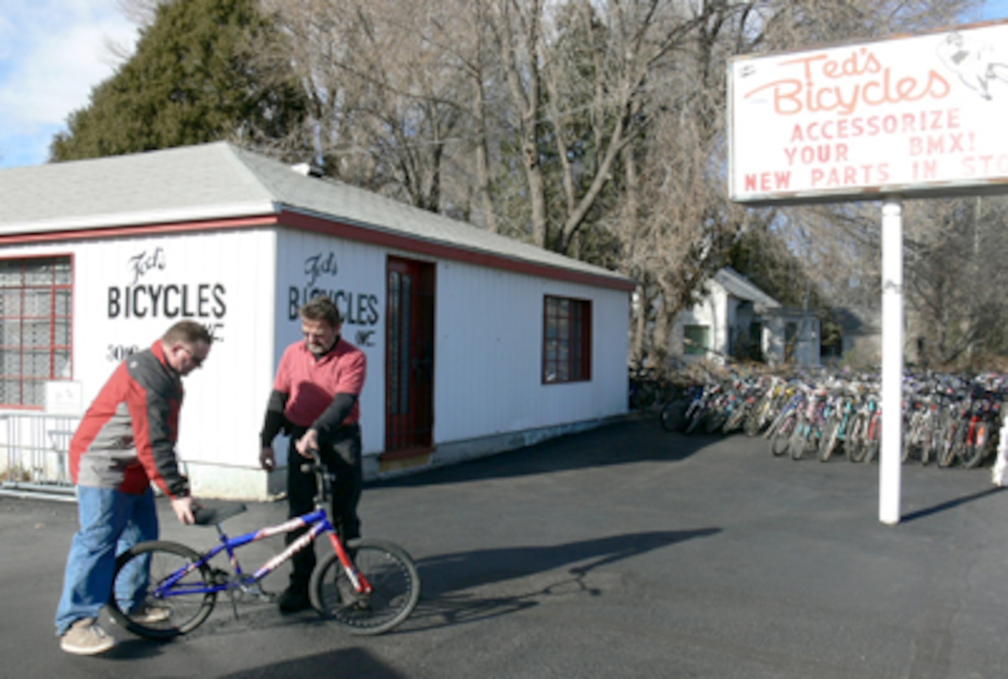 (Left) Maj. John Thomas gives one of three bikes he refurbished to Tony Hoewisch, the owner of Ted's Bicycles, Dec. 11, 2010, in Colorado Springs, Colo. These bicycles will be given to children and adults at the 28th annual Bob Telmosse Christmas Giveaway Dec. 20, 2010, in Colorado Springs. Major Thomas is the 721st Mission Support Group chief of plans and programs. He rebuilds discarded bikes and then donates them. (U.S. Air Force photo/Monica Mendoza)