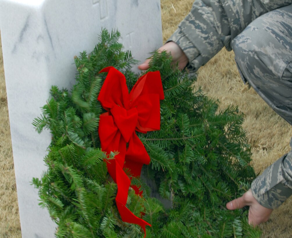 An Airman lays a wreath on the tombstone of a fallen veteran during the Wreaths Across America ceremony Dec. 11, 2010, at Fort Jackson National Cemetery in Columbia, S.C. The ceremony included a memorial presentation, recognition of prisoners of war, those still missing in action and Merchant Marines, a salute by a cannon battery and buglers. (U.S. Air Force photo/Airman 1st Class Daniel Phelps)
