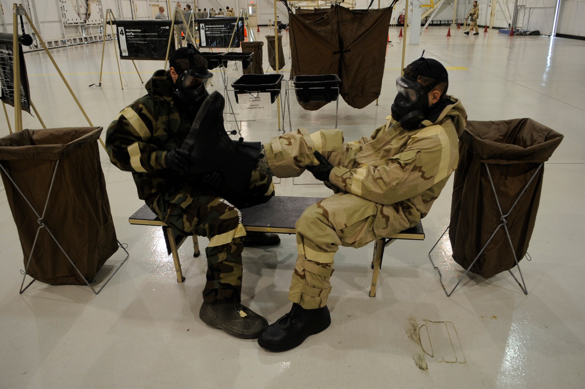 MOUNTAIN HOME AIR FORCE BASE, Idaho -- Airman Sabrina Crawford, 366th Medical Group, and Staff Sgt. Troy Zimmerman, 366th Civil Engineer Squadron, assist each other in the removal of simulated contaminated gear during an Ability to Survive and Operate Rodeo here Dec. 13 in Hangar 1331. The purpose of the ATSO Rodeo was to increase the critical real-world and Conventional Operational Readiness Exercise Phase II ATSO skills through combined academic and practical stations. (U.S. Air force photo by Senior Airman Angelina Drake)