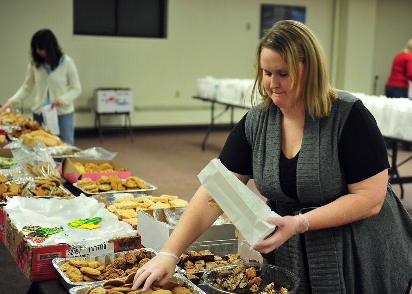 MINOT AIR FORCE BASE, N.D. -- Julia Coleman, Officer Spouse Club president and wife of Capt. Chris Coleman, 23rd Bomb Squadron electronic warfare officer, prepares bags of cookies to be distributed to dorm residents here Dec. 9. These packages consist of cookies donated by base personnel as well as companies and families of the local area as a way to spread holiday cheer. (U.S. Air Force photo/Senior Airman Michael J. Veloz)