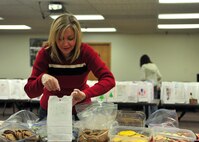MINOT AIR FORCE BASE, N.D. -- Colleen Coffelt, wife of Col. Christopher Coffelt, 91st Missile Wing vice commander, prepares bags of cookies to be distributed to dorm residents here Dec. 9. These packages consist of cookies donated by base personnel as well as companies and families of the local area as a way to spread holiday cheer. (U.S. Air Force photo/Senior Airman Michael J. Veloz)