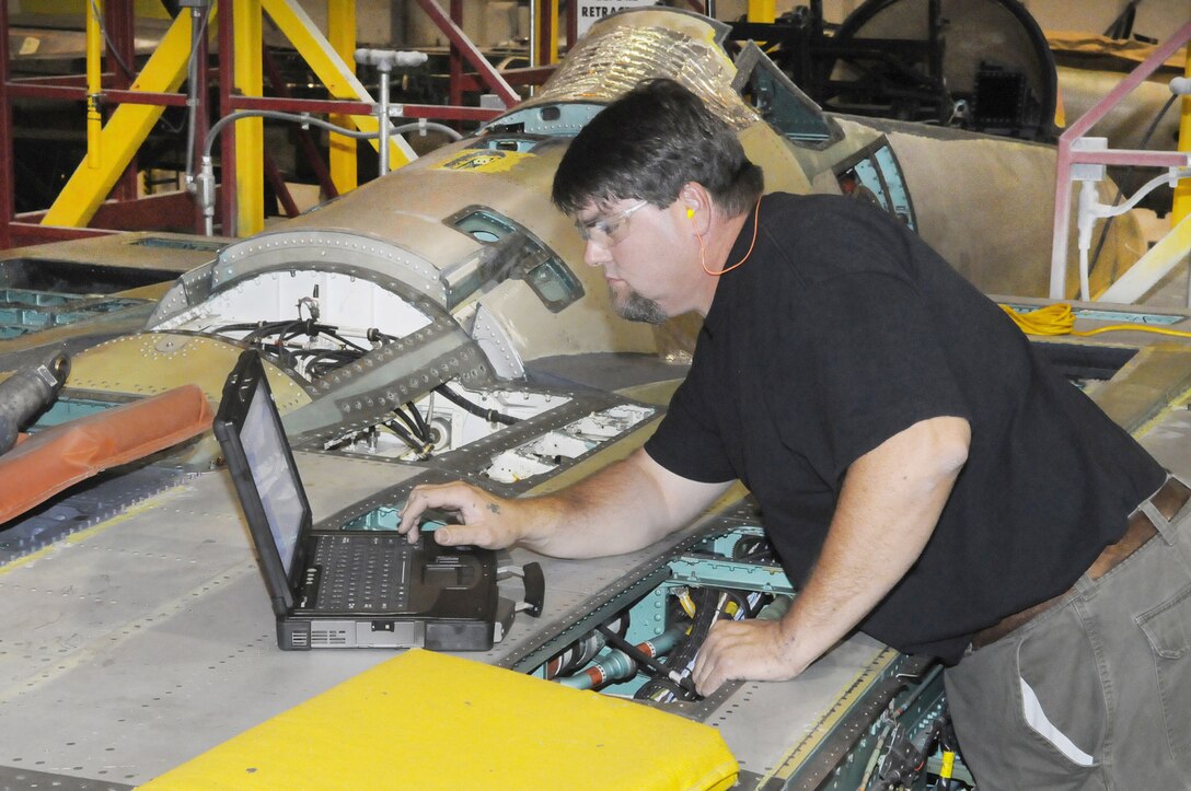 Michael Osborne utilizes an e-tool to work on an F-15 longitudinal and lateral bell crank Nov. 18, 2010 at Robins Air Force Base, Ga. Mr. Osborne is an F-15 aircraft mechanic. (U. S. Air Force photo/Sue Sapp)