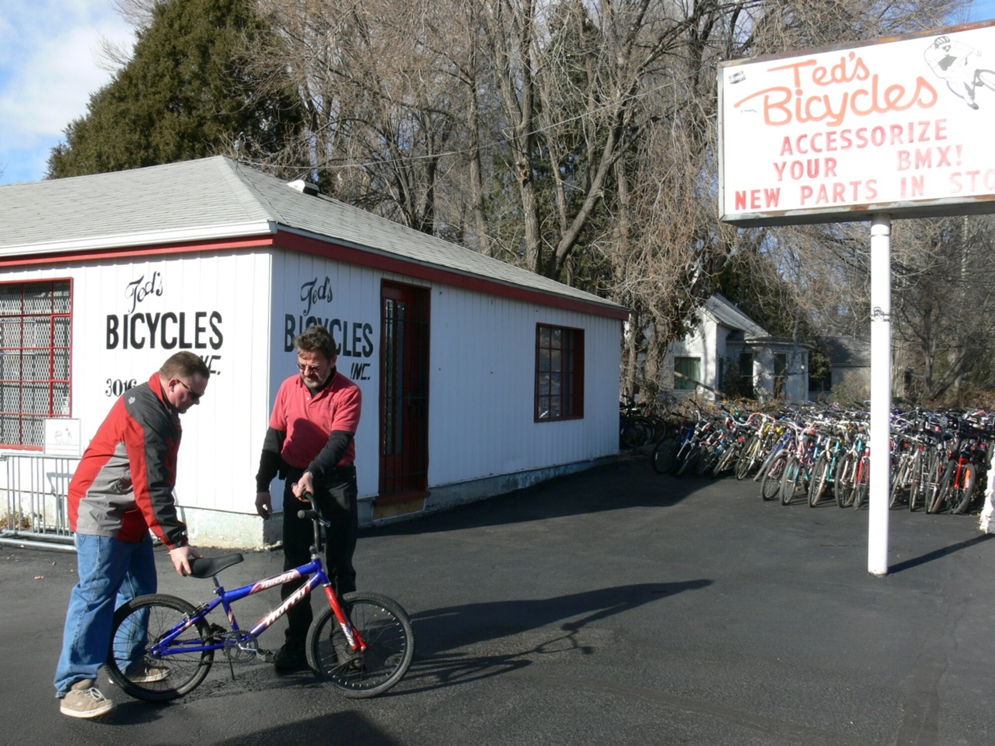 Maj. John Thomas, 721st Mission Support Group chief of plans and programs, (left) gives one of three bikes he found in a dumpster and refurbished to Ted's Bicycles shop owner Tony Hoewisch Dec. 11. Major Thomas takes discarded bikes and rebuilds them, then donates them. These bicycles will be given to children and adults at the 28th annual Bob Telmosse Christmas Giveaway 2010 Dec. 20 in Colorado Springs. (U.S. Air Force photo/Monica Mendoza)