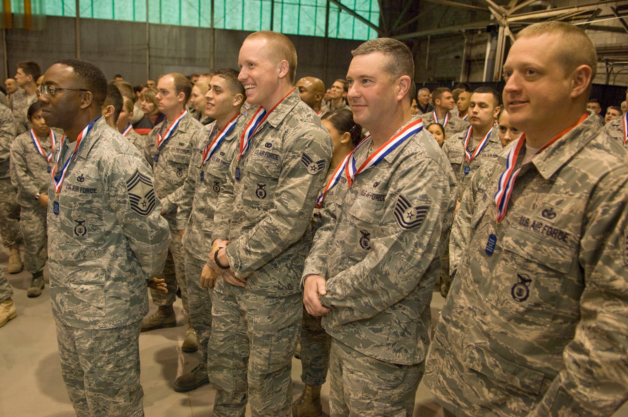 HANSCOM AIR FORCE BASE, Mass. – After walking across the stage, several heroes listen to the closing remarks during Heroes Homecoming on Dec. 10 in the Aero Club Hangar. More than 50 Hanscom personnel who have returned from deployments in the past six months and their families were honored during this pep rally-style event. (U.S. Air Force photo by Mark Wyatt)