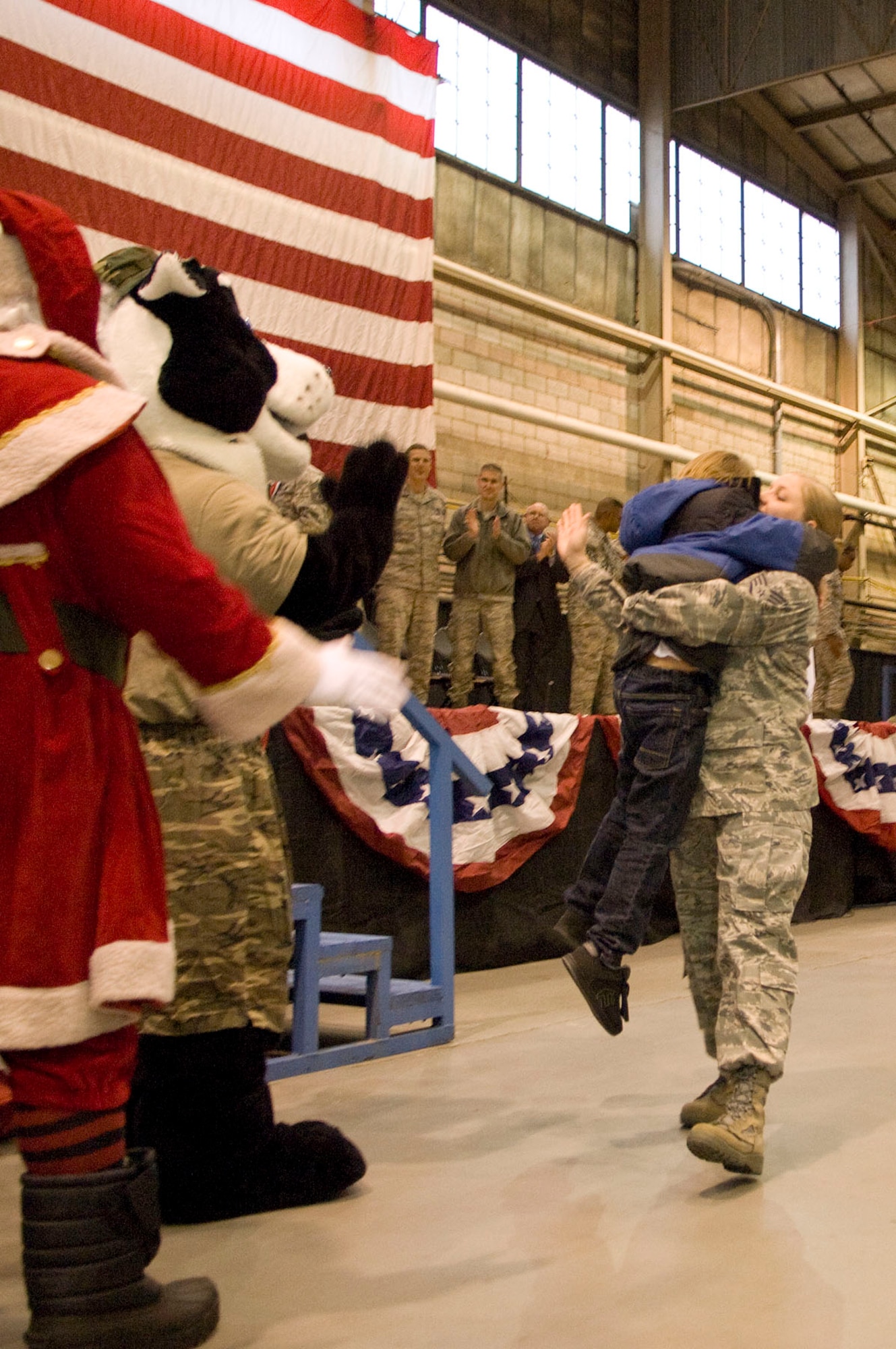 HANSCOM AIR FORCE BASE, Mass. – After walking across the stage to receive her medallion, Staff Sgt. Carrie Jordan gets a hug from her son Deven Smithling during Heroes Homecoming at the Aero Club Hangar on Dec. 10. More than 50 Hanscom personnel who have returned from deployments in the past six months and their families were honored during this pep rally-style event. (U.S. Air Force photo by Mark Wyatt)