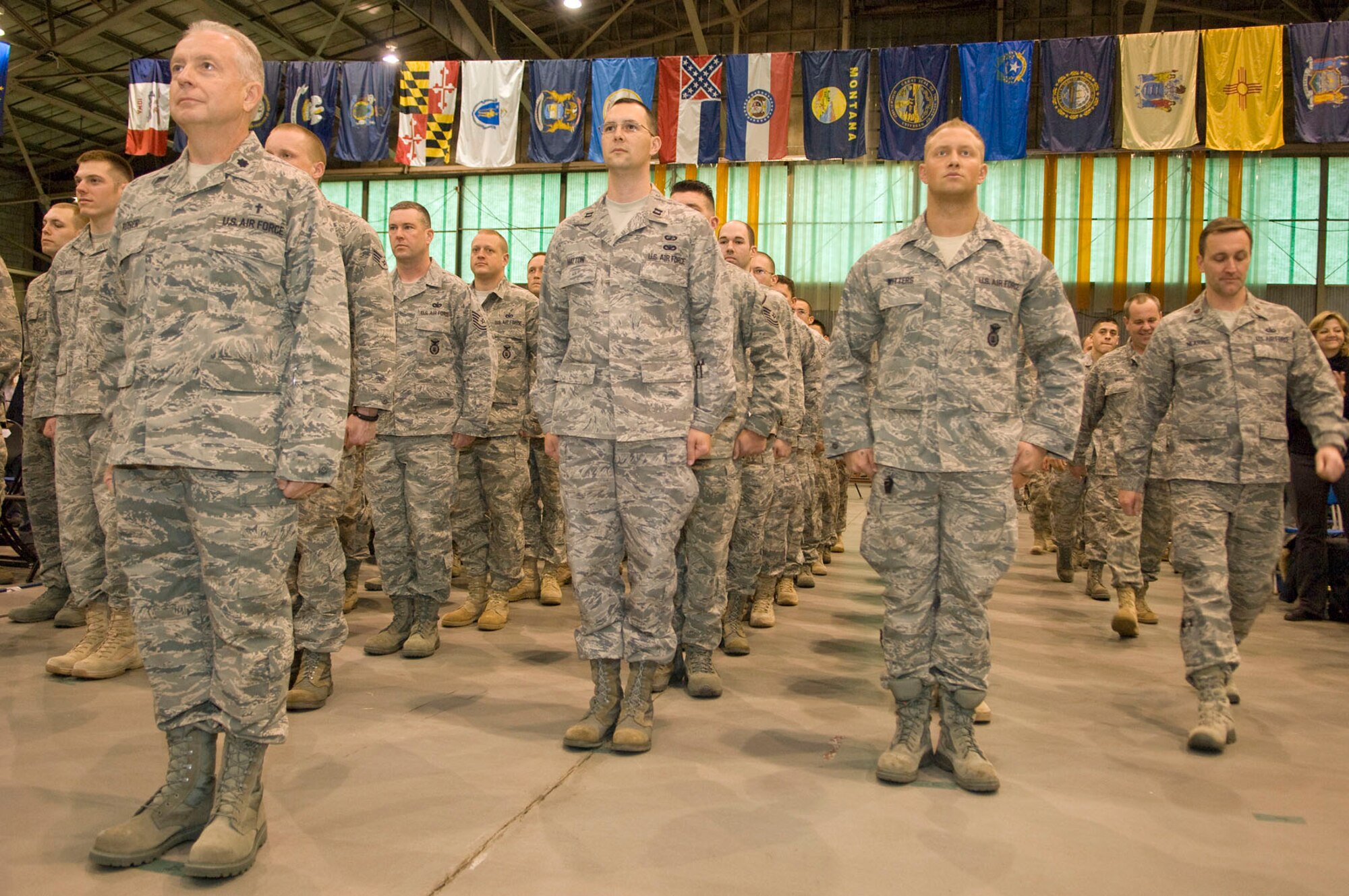 HANSCOM AIR FORCE BASE, Mass. – Led by Chaplain (Lt. Col.) Sam Rorer, Airmen file in to the Aero Club Hangar for Heroes Homecoming on Dec. 10. More than 50 Hanscom personnel who have returned from deployments in the past six months and their families were honored during this pep rally-style event. (U.S. Air Force photo by Mark Wyatt)