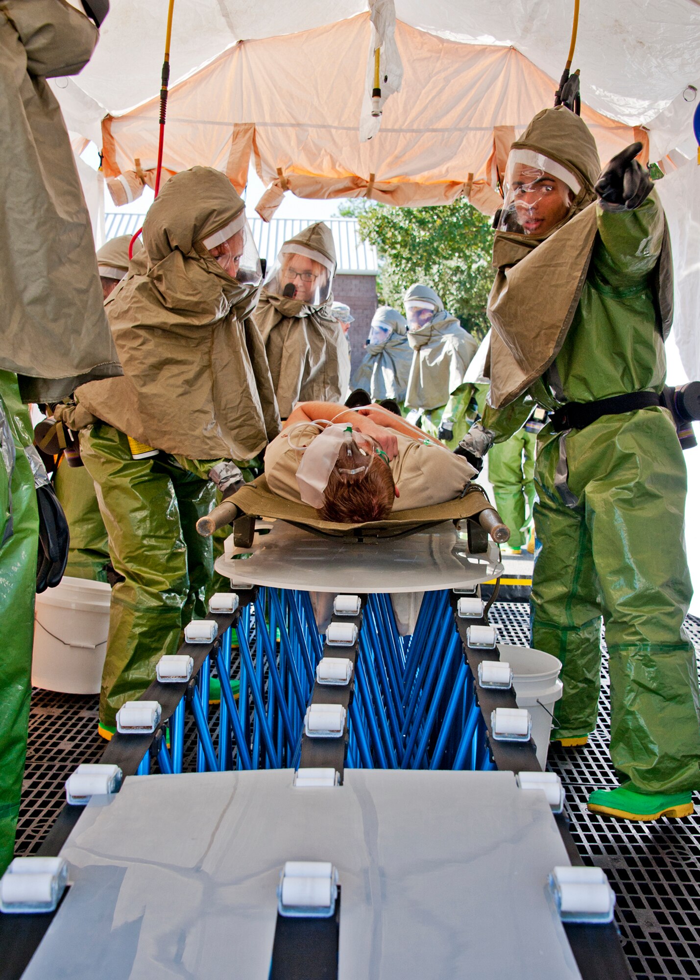 Airman 1st Class Pichardo, 96th Medical Group decontamination team, directs other Airmen where to be as a “victim” is moved through the sanitation tent Dec. 1.   After exiting the decontamination tent, victims were assessed by a triage team to determine what medical treatment was needed and how urgent the need was.  The base's Chemical Biological Nuclear Explosive exercise tested Eglin's first responders such as security forces and fire department as well as the medical group's emergency technicians.  96th MDG Airmen set up a decontamination tent to process the victims through before providing detailed medical attention.   (U.S. Air Force photo/ Samuel King) 