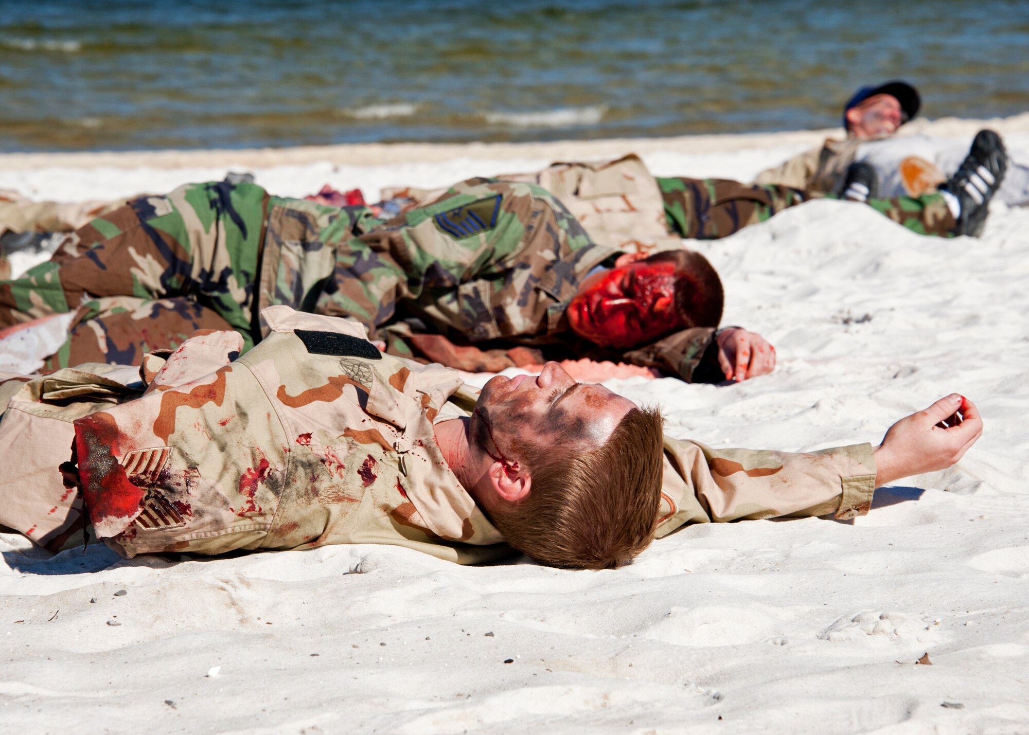 Victims of a simulated chlorine attack lie on the beach at Post'l Point Dec. 1 during the base's Chemical Biological Nuclear Explosive exercise.  The exercise tested Eglin's first responders such as security forces and fire department as well as the medical group's emergency technicians.  96th MDG Airmen set up a decontamination tent to process the victims through before providing detailed medical attention.   (U.S. Air Force photo/ Samuel King) 