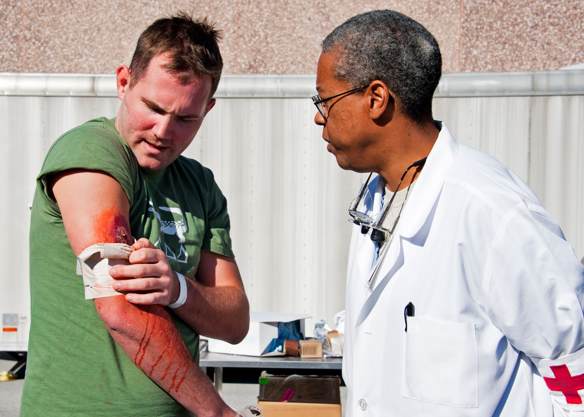 Lt. Col. Val Hagans, 96th Medical Group, examines a “victim’s” wounds at the triage area of the hospital.  After exiting the decontamination tent, victims were assessed by a triage team to determine what medical treatment was needed and how urgent the need was.  The base's Chemical Biological Nuclear Explosive exercise tested Eglin's first responders such as security forces and fire department as well as the medical group's emergency technicians.  96th MDG Airmen set up a decontamination tent to process the victims through before providing detailed medical attention.   (U.S. Air Force photo/ Samuel King)