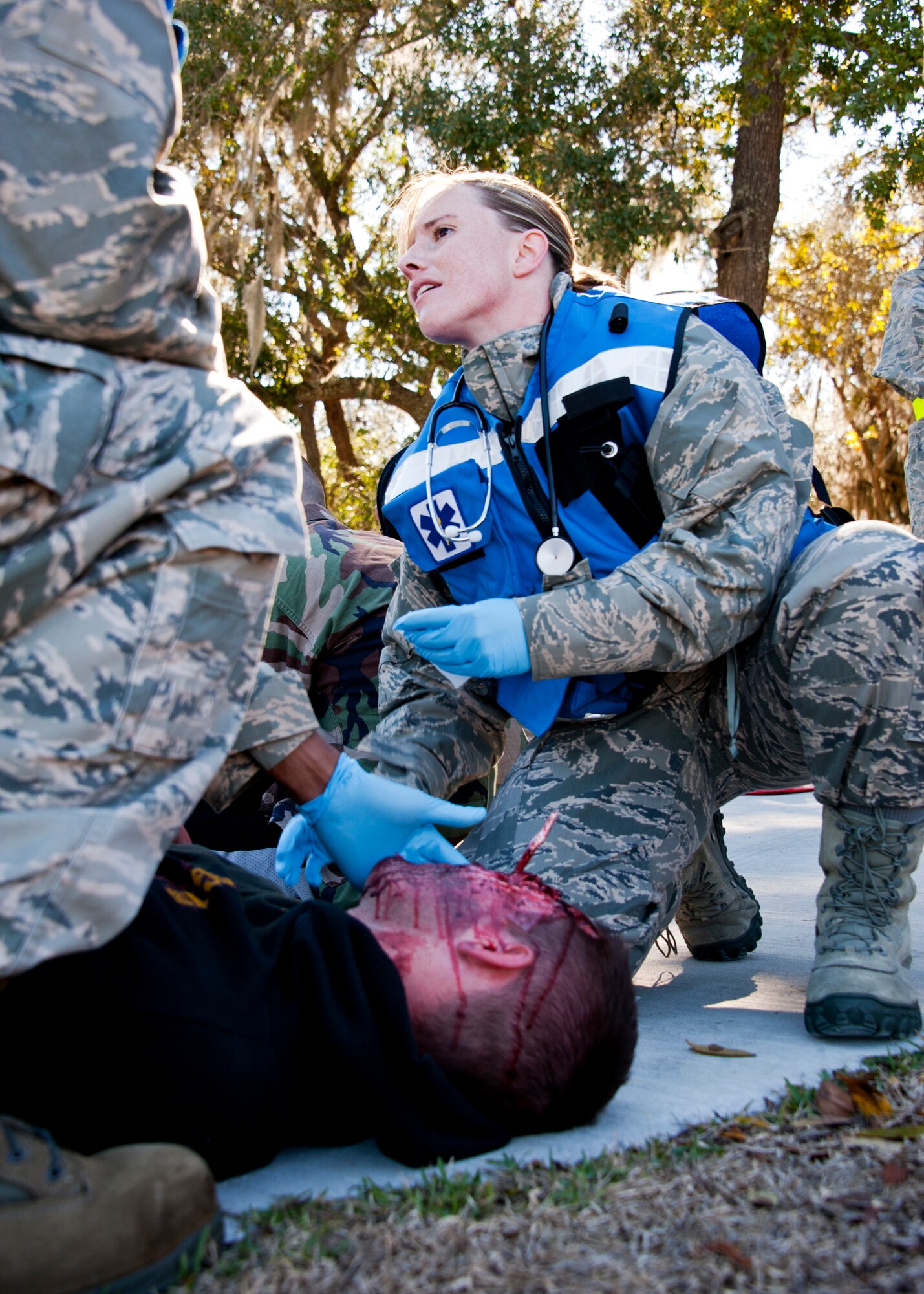 Staff Sgt. Vaulta Hanni, 96th Medical Group, calls for more bandages for a “victim” outside the contaminated zone at Post'l Point Dec. 1.  The base's Chemical Biological Nuclear Explosive exercise tested Eglin's first responders such as security forces and fire department as well as the medical group's emergency technicians.  96th MDG Airmen set up a decontamination tent to process the victims through before providing detailed medical attention.   (U.S. Air Force photo/ Samuel King)