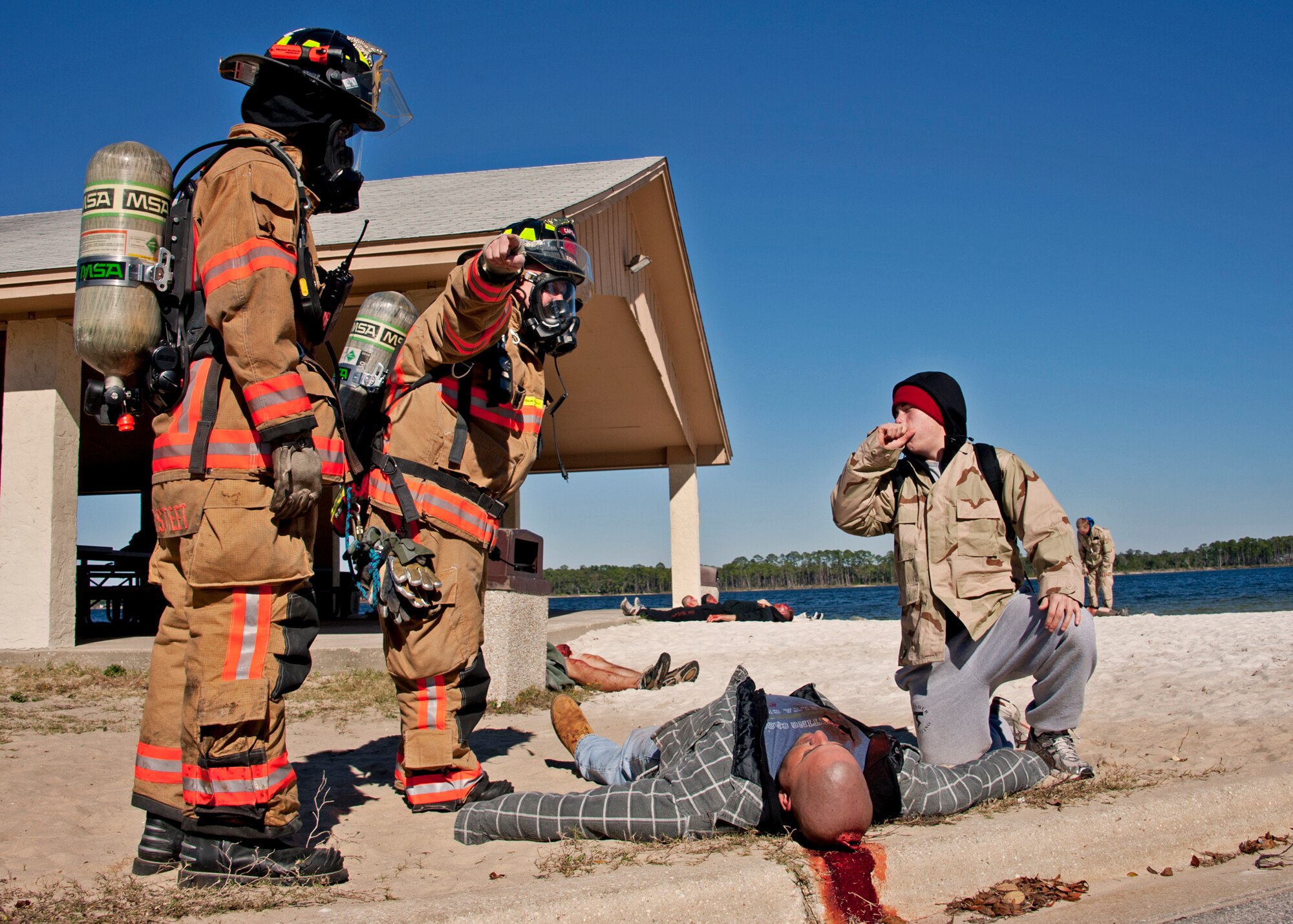 Christopher Hoffman,96th Civil Engineer Squadron firefighter, directs “victims” out of the contaminated zone at Post'l Point Dec. 1.  The base's Chemical Biological Nuclear Explosive exercise tested Eglin's first responders such as security forces and fire department as well as the medical group's emergency technicians.  96th Medical Group Airmen set up a decontamination tent to process the victims through before providing detailed medical attention.   (U.S. Air Force photo/ Samuel King)