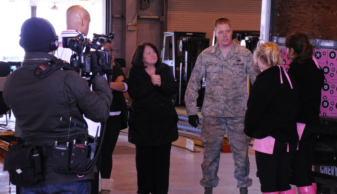 Staff Sgt. Ryan Garrison, 89th Aerial Port Squadron air transportation specialist, explains to Katherine Kallinis and Sophie LaMontagne, sisters and co-owners of Georgetown Cupcake, and camera crew, the process of loading the cupcakes onto the pallets and getting them out to the aircraft Dec. 11. The footage will be used for the show “DC Cupcakes” aired on the TLC network. The Georgetown Cupcake Co. shipped approximately 8,000 cupcakes to troops in Afghanistan (U.S. Air Force photo by: Bahja J. Jones) 