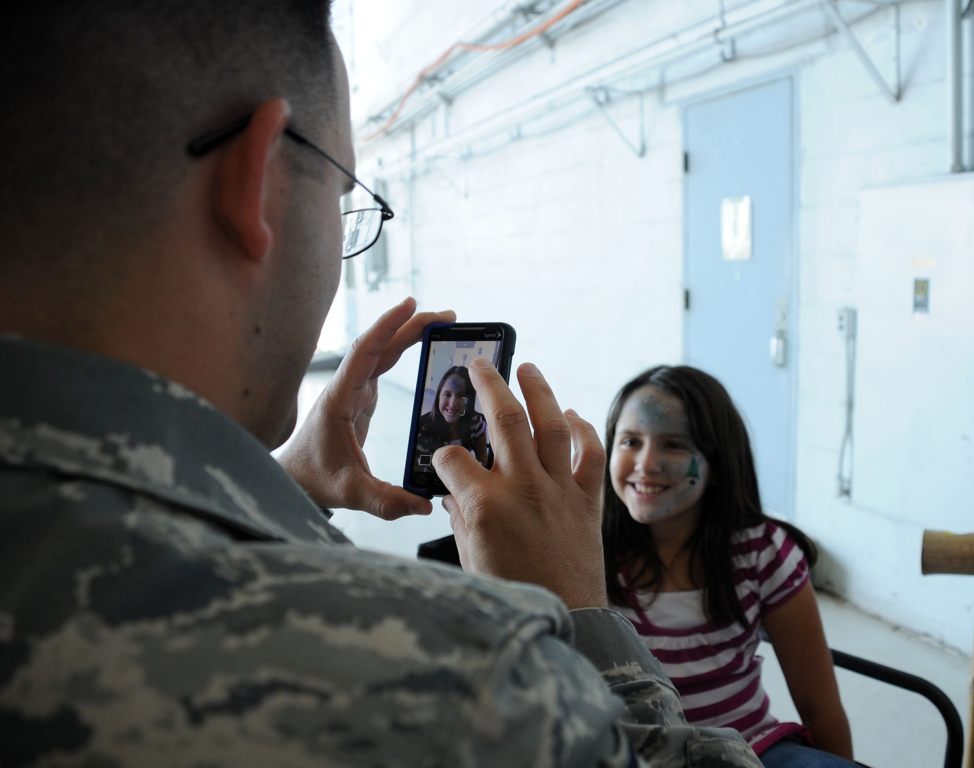 MacDill Air Force Base, Fla. -- Master Sergeant Charly Berio, with the 927th Force Support Squadron, captures the face painting his daughter ten-year-old Angelica received at the holiday party here Dec. 4.  In addition to face painting and other activities for kids, the party also had activities for the adults in the unit. (Official United States Air Force photo by Staff Sgt. Shawn C. Rhodes)