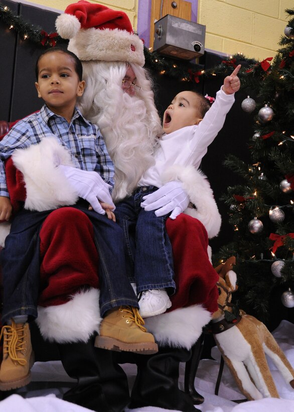 Jada Reyno, with her brother Jordan, children of Tiffany and Michael Reyno, Secretary of Defense office personnel communicator, enthusiastically tells Santa what she wants for Christmas during Breakfast with Santa at the Youth Center Dec. 11. Breakfast with Santa is an annual event hosted by the Youth Center that featured performances by Agency 9 Performing Dance Company, Shabach praise dance team, and a Tae Kwon Do demonstration. (U.S. Air Force photo by: Airman 1st Class Bahja J. Jones)