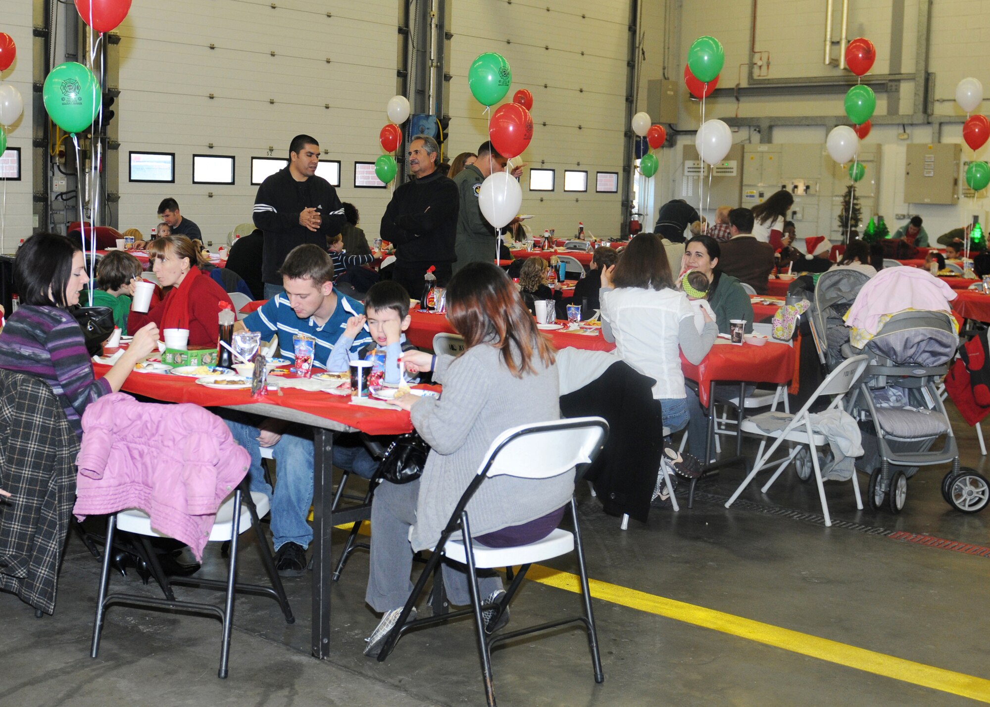RAF MILDENHALL, England -- Parents and children eat pancakes, eggs and sausage Dec. 11, 2010, at the RAF Mildenhall Fire Department during the annual Breakfast with Santa.  Children also enjoyed bouncy castles, an inflatable slide, crafts and presents from Santa.  (U.S. Air Force photo by/Senior Airman Tabitha M. Lee)