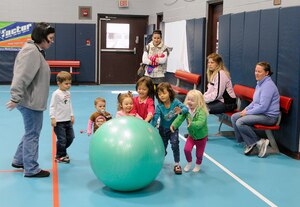 Children push an exercise ball at the Youth Center on Joint Base Charleston - Air Base during a Military Moms weekly meeting December 9, 2010. The Military Moms group is made up of more than 150 active participants with the goal of helping military moms acclimate to the military lifestyle. (U.S. Navy photo/Mass Communication Specialist 1st Class Jennifer R. Hudson)