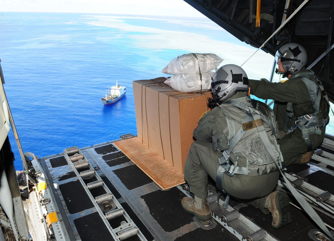 Airmen from the 36th Airlift Squadron, Yokota Air Base, Japan,  lookout upon the Islands of Yap prior to pushing a box of humanitarian assistance goods out of a U.S. Air Force C-130 Hercules call sign ?Santa 23? to its drop-zone during Operation Christmas Drop, Dec. 14. Operation Christmas Drop is the Air Force?s longest-running humanitarian which began in 1952. Airmen today continue the tradition delivering supplies to remote islands of the Commonwealth of the Northern Marianas Islands, Yap, Palau, Chuuk and Pohnpei. (U.S. Air Force photo/ Senior Airman Nichelle Anderson)