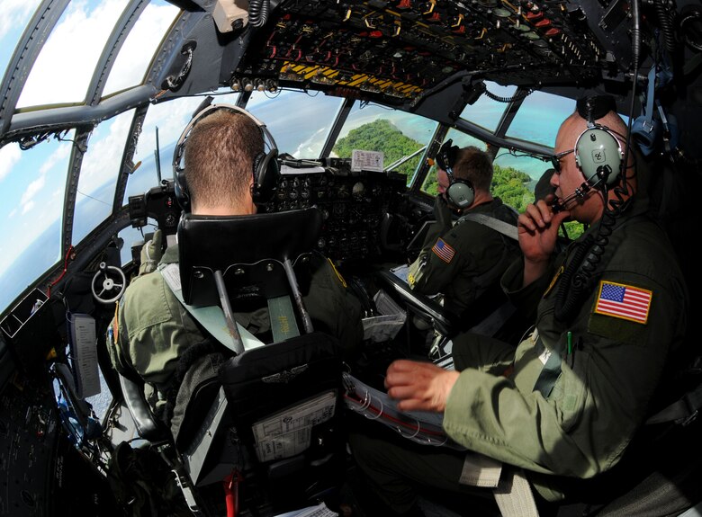 Capt. Steven Martina, a 36th Airlift Squadron C-130 Hercules navigator from Yokota Air Base, Japan, communicates to the flight crew during Operation Christmas Drop, Dec. 14. Airmen from the 36th Wing, Andersen Air Force Base, Guam and the 36th Airlift Squadron, Yokota Air Base, Japan, come together each year as a part of a training exercise to drop thousands of pounds of donated supplies over the Micronesian Islands. This year more than 20,000 pounds of supplies, worth more than $93,000 will be dropped over 55 Micronesian Islands throughout the week. (U.S. Air Force photo/ Senior Airman Nichelle Anderson)  