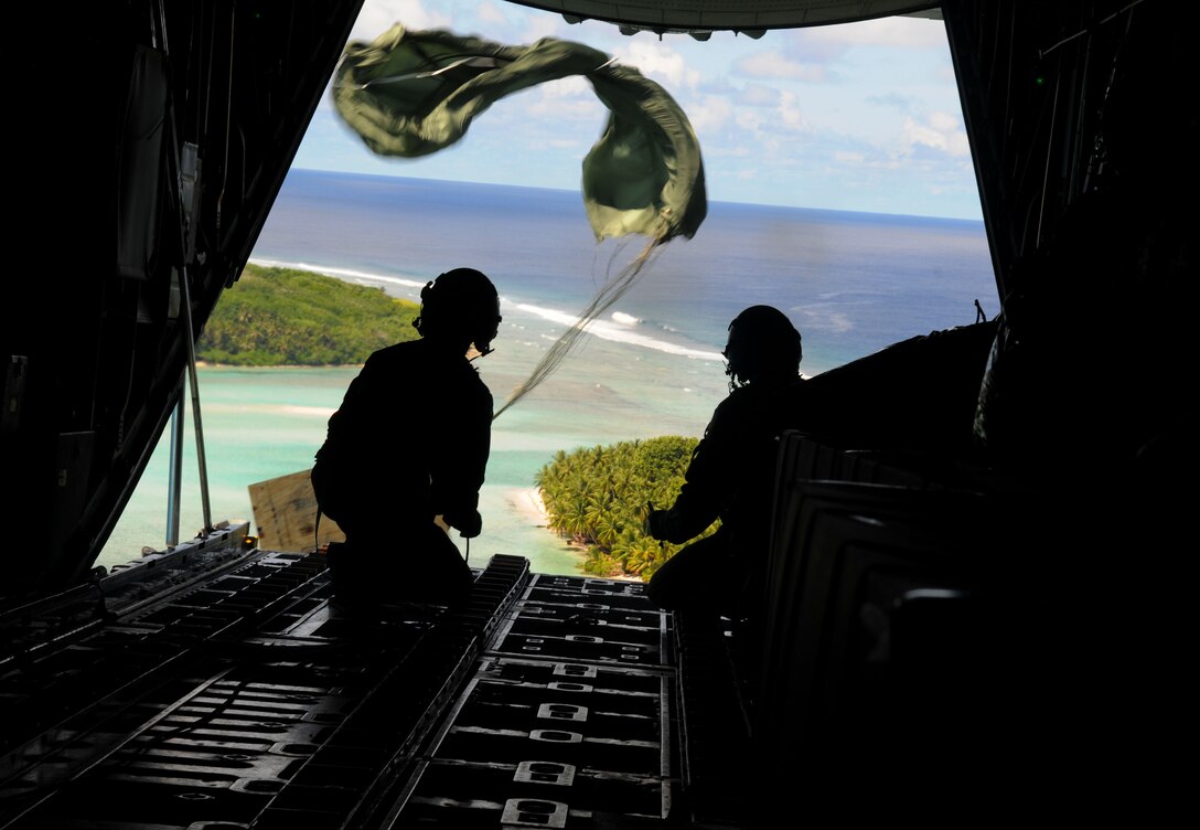 Airmen from the 36th Airlift Squadron, Yokota Air Base, Japan, watch as the parachute deploys and a box of humanitarian goods travels to the Yap Islands below during Operation Christmas Drop, Dec. 14. Operation Christmas Drop is the Air Force?s longest-running humanitarian which began in 1952. What started as a WB-50 aircrew returning to Guam on its final flight before Christmas has turned into the longest running humanitarian campaign in the history of the U.S. Air Force and the entire world. (U.S. Air Force photo Senior Airman Nichelle Anderson)
