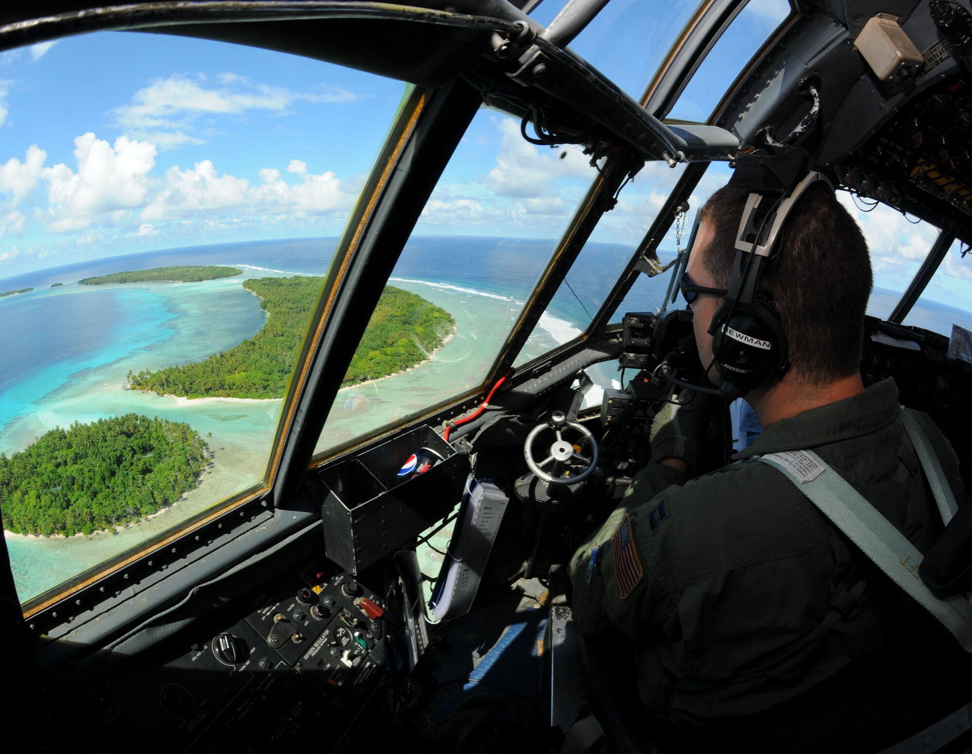 Capt. Phillip Newman, a 36th Airlift Squadron C-130 Hercules pilot from Yokota Air Base, Japan, looks out upon the Yap Islands during Operation Christmas Drop, Dec. 14. Airmen from the 36th Wing, Andersen Air Force Base, Guam and the 36th Airlift Squadron, Yokota Air Base, Japan, come together each year as a part of a training exercise to drop thousands of pounds of donated supplies over the Micronesian Islands. This year more than 60 boxes will be dropped to 55 Island weighing in at more than 20,000 pounds. (U.S. Air Force photo/ Senior Airman Nichelle Anderson) 