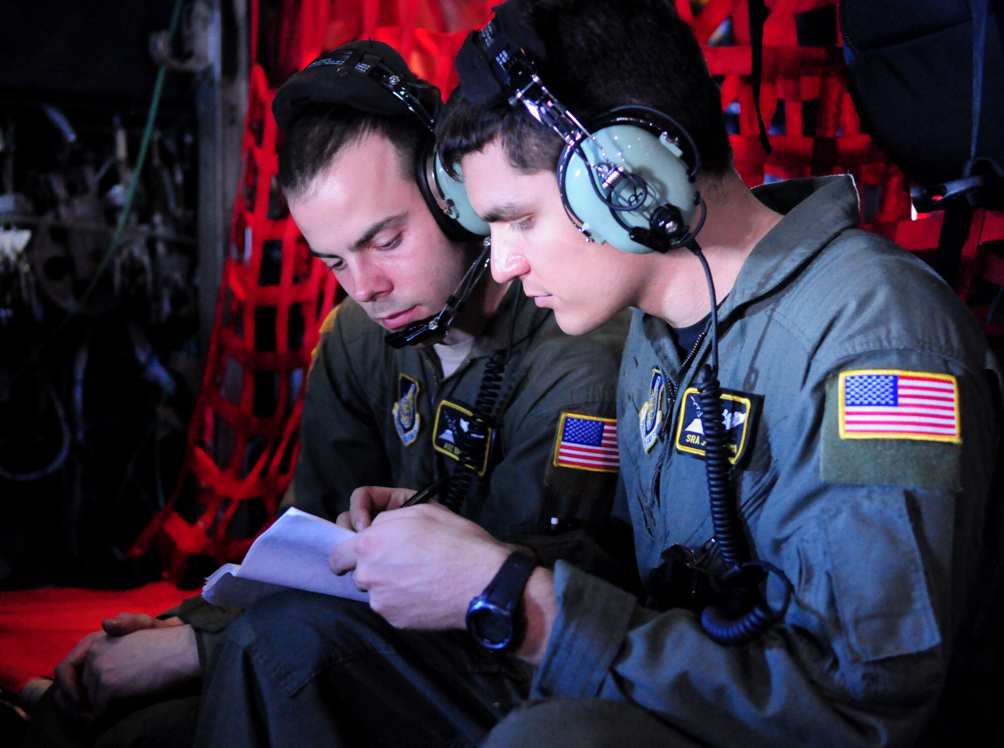 Loadmasters from 36th Airlift Squadron, Yokota Air Base, Japan, Airman 1st Class Brandon Lee and Senior Airman Joseph Doria, review mission documents after completing airdrops over the Yap Islands of Woleai Falalop, Woleai Tagailap, Woleai Saliap, Woleai Wottegai, Woleai Falalis and Eauripik with a combined population of more than 1,140 people during Operation Christmas Drop, Dec. 14. Airmen from the 36th Wing, Andersen Air Force Base, Guam and the 36th Airlift Squadron, Yokota Air Base, Japan, come together each year as a part of a training exercise to drop thousands of pounds of donated supplies over the Micronesian Islands. This year more than 20,000 pounds of supplies, worth more than $93,000 will be dropped over 55 Micronesian Islands throughout the week. (U.S. Air Force photo/ Senior Airman Nichelle Anderson)  