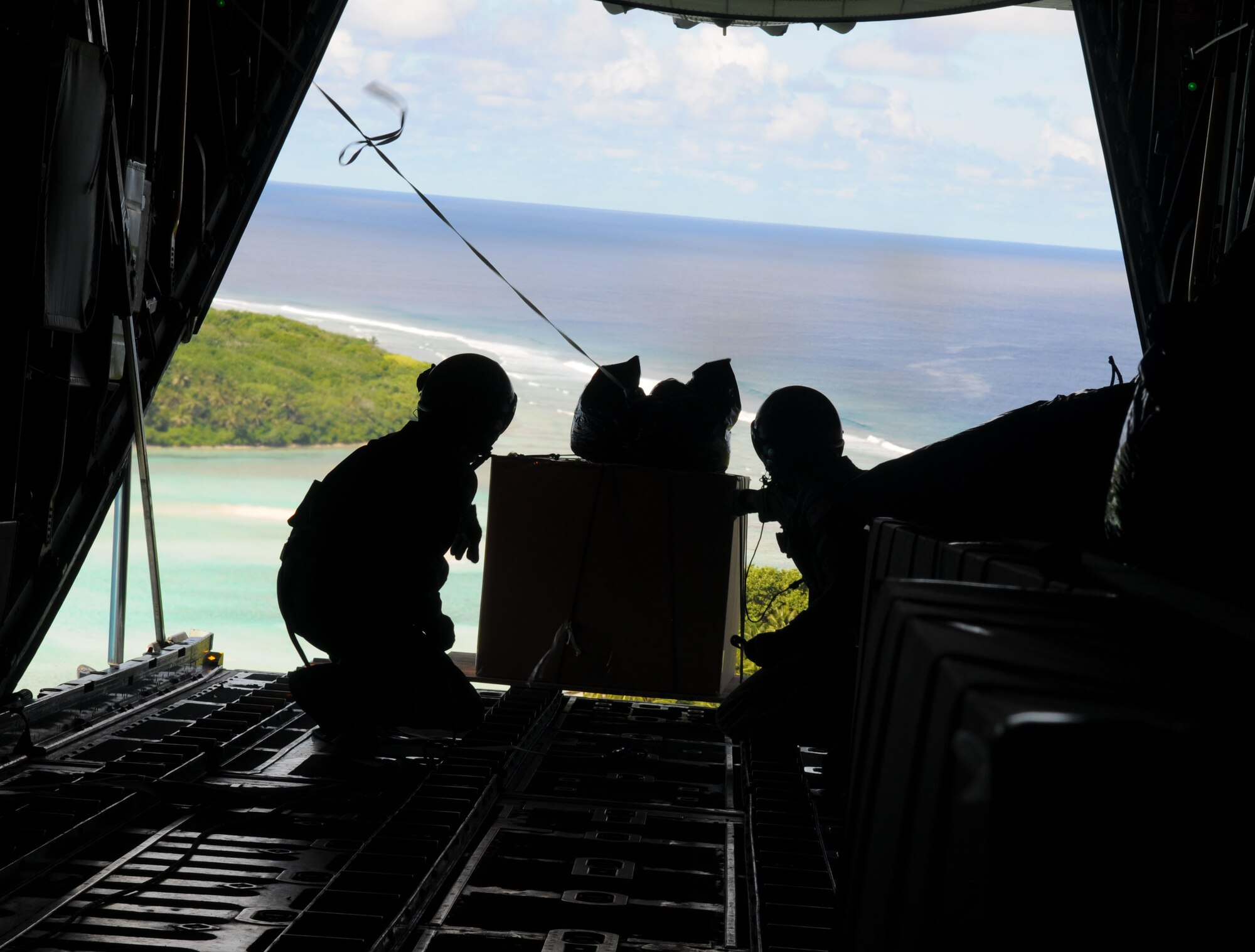 Airmen from the 36th Airlift Squadron, Yokota Air Base, Japan, lookout upon the Islands of Micronesia during Operation Christmas Drop, Dec. 14. Operation Christmas Drop is the Air Force?s longest-running humanitarian which began in 1952. Airmen today continue the tradition delivering supplies to remote islands of the Commonwealth of the Northern Marianas Islands, Yap, Palau, Chuuk and Pohnpei. (U.S. Air Force photo/ Senior Airman Nichelle Anderson)