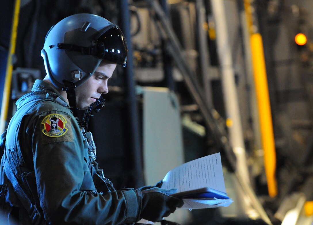 Airman 1st Class Brandon Lee, a 36th Airlift Squadron loadmaster from Yokota Air Base, Japan, reviews mission procedures during Operation Christmas Drop, Dec. 14. Airmen from the 36th Wing, Andersen Air Force Base, Guam and the 36th Airlift Squadron, Yokota Air Base, Japan, come together each year as a part of a training exercise to drop thousands of pounds of donated supplies over the Micronesian Islands. This year more than 20,000 pounds of supplies, worth more than $93,000 will be dropped over 55 Micronesian Islands throughout the week. (U.S. Air Force photo/ Senior Airman Nichelle Anderson)  