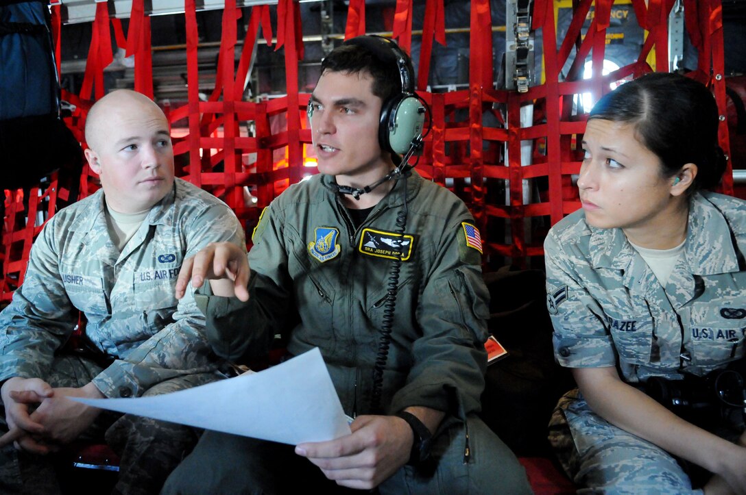 Senior Airman Joseph Doria, a 36th Airlift Squadron loadmaster from Yokota Air Base, Japan,  speaks with Armed Forces Network Tokyo, broadcaster Senior Airman Chad Usher and 36th Wing, Public Affairs, broadcaster Airman 1st Class Mariko Frazee about the airdrop route during Operation Christmas Drop Dec. 14. Airmen from the 36th Wing, Andersen Air Force Base, Guam and the 36th Airlift Squadron, Yokota Air Base, Japan, come together each year as a part of a training exercise to drop thousands of pounds of donated supplies over the Micronesian Islands. This year more than 20,000 pounds of supplies, worth more than $93,000 will be dropped over various Micronesian Islands throughout the week. (U.S. Air Force photo/ Senior Airman Nichelle Anderson)