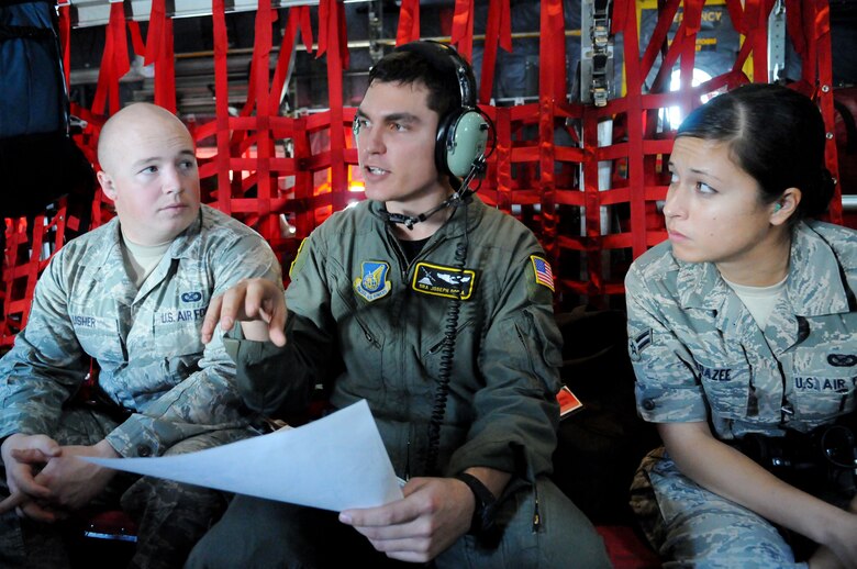 Senior Airman Joseph Doria, a 36th Airlift Squadron loadmaster from Yokota Air Base, Japan,  speaks with Armed Forces Network Tokyo, broadcaster Senior Airman Chad Usher and 36th Wing, Public Affairs, broadcaster Airman 1st Class Mariko Frazee about the airdrop route during Operation Christmas Drop Dec. 14. Airmen from the 36th Wing, Andersen Air Force Base, Guam and the 36th Airlift Squadron, Yokota Air Base, Japan, come together each year as a part of a training exercise to drop thousands of pounds of donated supplies over the Micronesian Islands. This year more than 20,000 pounds of supplies, worth more than $93,000 will be dropped over various Micronesian Islands throughout the week. (U.S. Air Force photo/ Senior Airman Nichelle Anderson)