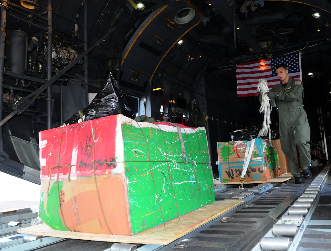 Staff Sgt. Keo Khamone, a 36th Airlift Squadron loadmaster from Yokota Air Base, Japan, prepares goods for take-off during Operation Christmas Drop at Andersen Air Force Base, Guam, Dec. 14. Airmen from the 36th Wing, Andersen Air Force Base, Guam and the 36th Airlift Squadron, Yokota Air Base, Japan, come together each year as a part of a training exercise to drop thousands of pounds of donated supplies over the Micronesian Islands. This year more than 20,000 pounds of supplies, worth more than $93,000 will be dropped over various Micronesian Islands throughout the week. (U.S. Air Force photo/ Senior Airman Nichelle Anderson)  