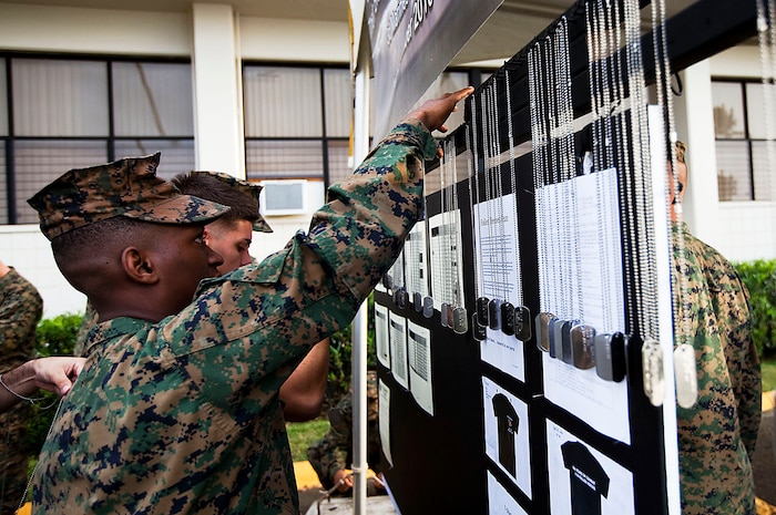 Cpl. Hilary Dalson, an amphibious assault vehicle crew chief, Combat Assault Company, 3rd Marine Regiment, hangs the dog tags of fallen Marines and sailors from 3rd Marine Regiment before the Fallen Heroes Run on Marine Corps Base Hawaii, Dec. 14, 2010. Since 2004, 116 Marines and sailors from 3rd Marine Regiment have been killed during operations in Afghanistan and Iraq. On Dec. 14 and 15, teams of at least two Marines or sailors in combat boots and camouflage trousers ran a 2-mile evolution 116 times — one for each fallen hero. The route took them from the 3rd Marine Regiment headquarters building to the Pacific War Memorial here and back.