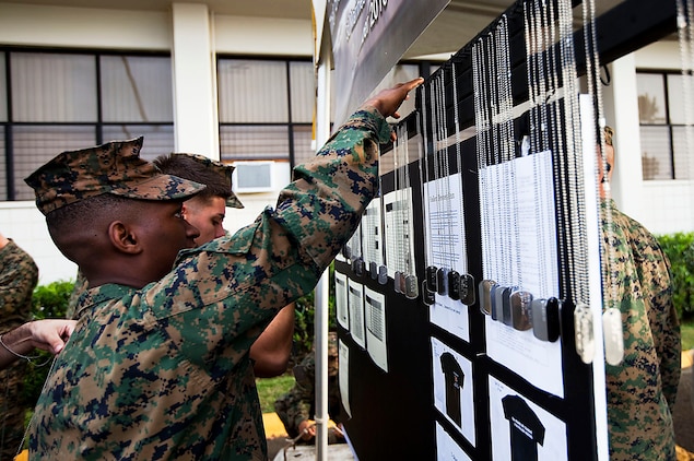 Cpl. Hilary Dalson, an amphibious assault vehicle crew chief, Combat Assault Company, 3rd Marine Regiment, hangs the dog tags of fallen Marines and sailors from 3rd Marine Regiment before the Fallen Heroes Run on Marine Corps Base Hawaii, Dec. 14, 2010. Since 2004, 116 Marines and sailors from 3rd Marine Regiment have been killed during operations in Afghanistan and Iraq. On Dec. 14 and 15, teams of at least two Marines or sailors in combat boots and camouflage trousers ran a 2-mile evolution 116 times — one for each fallen hero. The route took them from the 3rd Marine Regiment headquarters building to the Pacific War Memorial here and back.