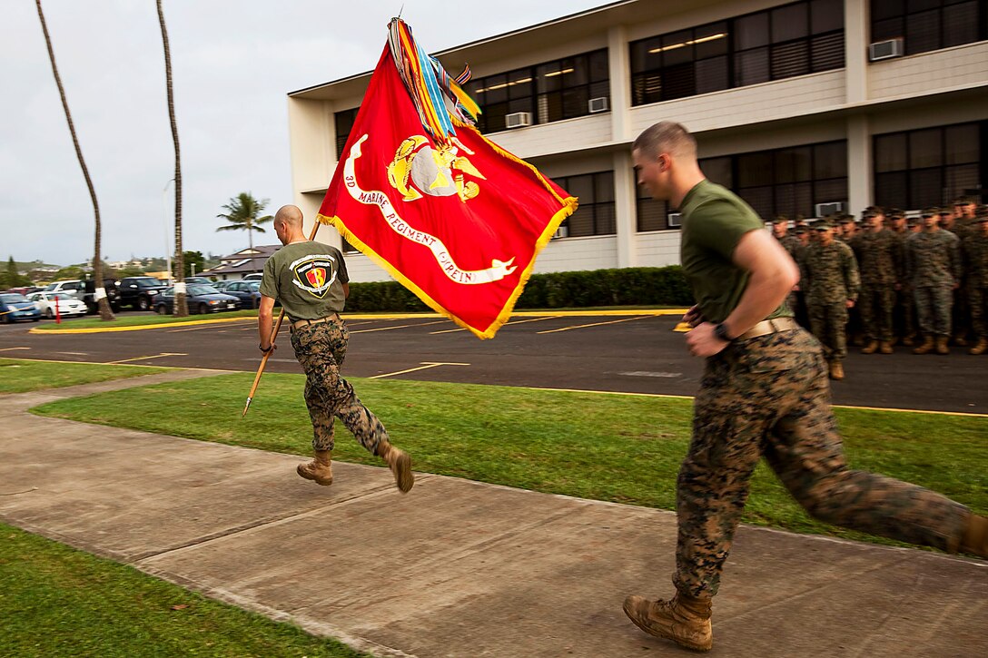 1st Lt. Gregory Veteto, executive officer, Company C, 1st Battalion, 3rd Marine Regiment, and 2nd Lt. Ian Merry, platoon commander, Company C, 1/3, run with the 3rd Marine Regiment battle colors to begin the Fallen Heroes Run on Marine Corps Base Hawaii, Dec. 14, 2010. Since 2004, 116 Marines and sailors from 3rd Marine Regiment have been killed during operations in Afghanistan and Iraq. On Dec. 14 and 15, teams of at least two Marines or sailors in combat boots and camouflage trousers ran a 2-mile evolution 116 times — one for each fallen hero. The route took them from the 3rd Marine Regiment headquarters building to the Pacific War Memorial here and back.