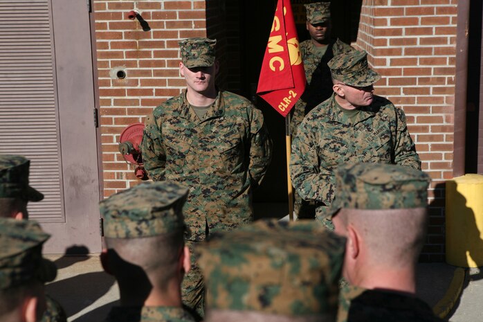 Sgt. Kevin A. Koffler, a motor transportation operator with Combat Logistics Regiment 2, 2nd Marine Logistics Group, stands in the middle of a crowd as Col. Kenneth Enzor, 2nd MLG chief of staff, speaks on his behalf during a Purple Heart ceremony aboard Camp Lejeune, N.C., Dec. 15, 2010. Koffler received the award for injuries sustained when his vehicle struck an improvised explosive device three weeks into his deployment to Afghanistan in Aug. 2010, with Combat Logistics Battalion 2, 2nd MLG. (U.S. Marine Corps photo by Pfc. Franklin E. Mercado)