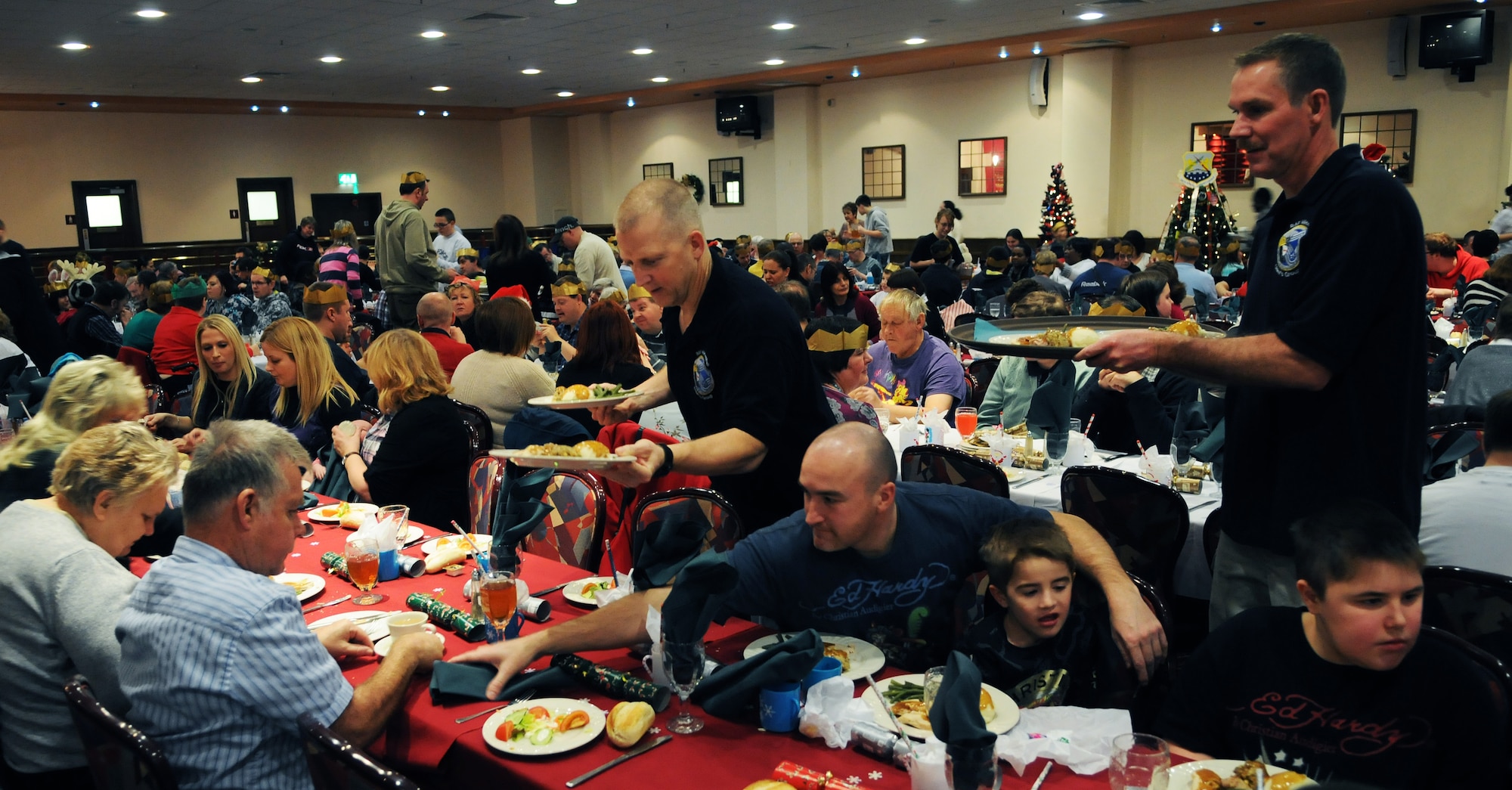 RAF MILDENHALL, England -- Chief master sergeants from the RAF Mildenhall Chief's Group serve meals to more than 350 attendees of the Special Persons' Holiday Party here Dec. 11, 2010. About 20 schools traveled from up to four hours to attend the event that included food, dancing and personalized Christmas gifts for the guests. (U.S. Air Force photo/Staff Sgt. Thomas Trower)