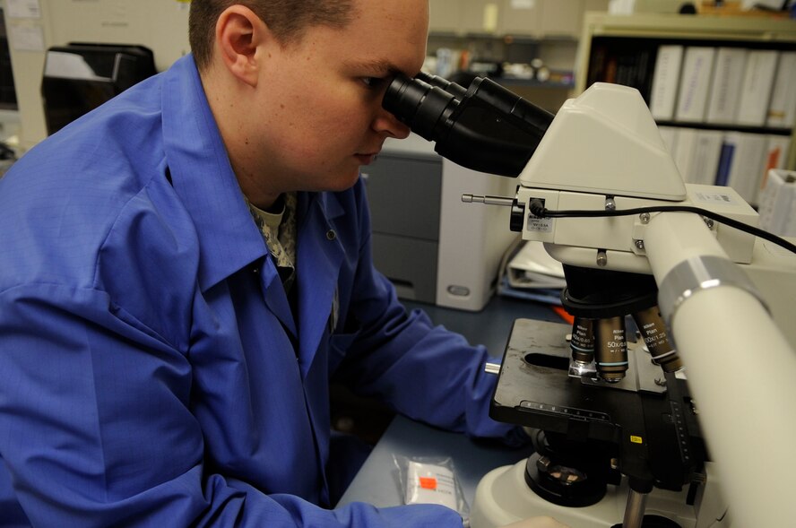 Senior Airman Marthinus Taljaard, 2nd Medical Group clinical laboratory technician, uses a microscope to examine a patient's blood sample slide at the 2 MDG lab at Barksdale Air Force Base, La., Dec. 15. The 2 MDG laboratory draws more than 89,000 samples a year. (U.S. Air Force photo/ Staff Sgt. Terri Barriere)